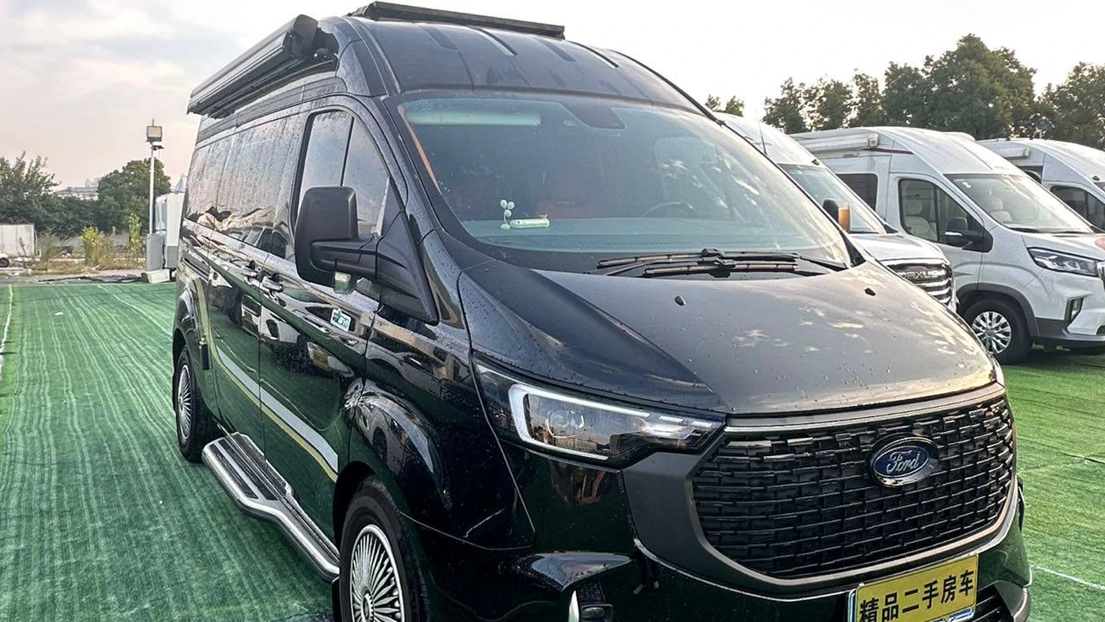 Чёрный Ford T6 на стоянке, вид спереди слева
